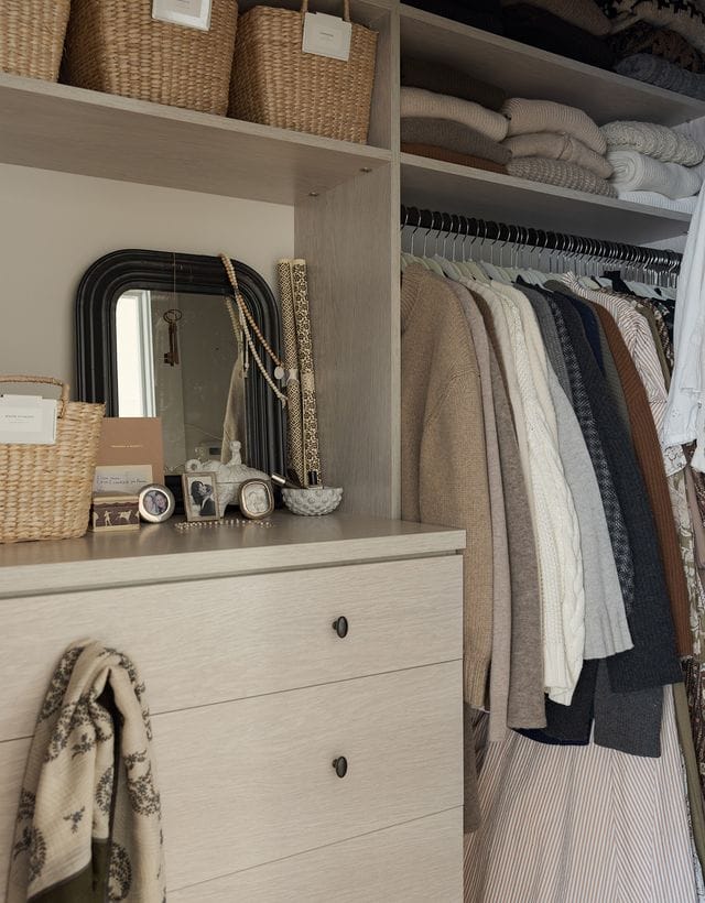 Walk in closet organization with shelving, built in dresser and hanging rods for clothes in light wood finish by California Closets