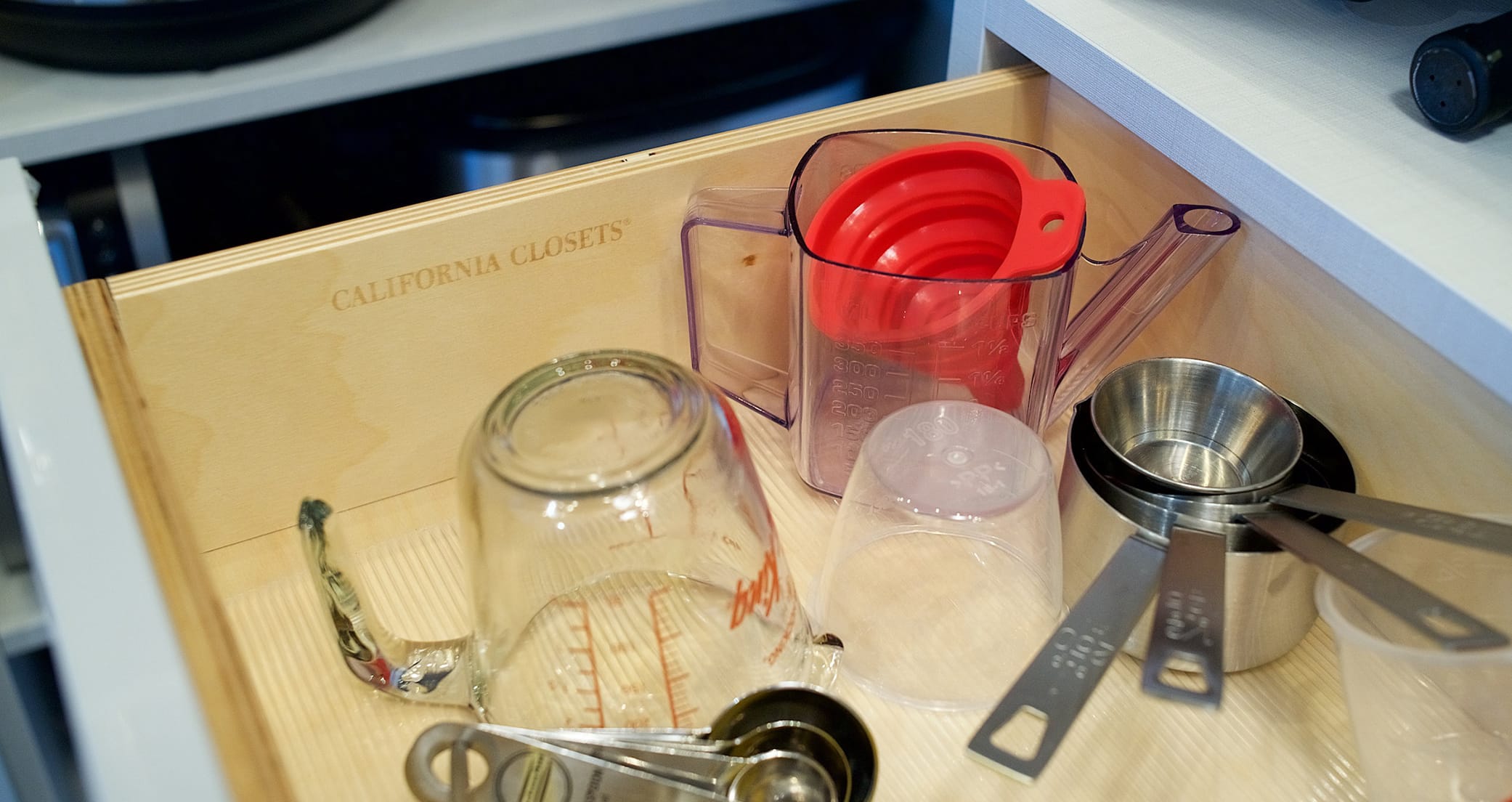 Pantry kitchen drawer for gadgets in customized wood finish by California Closets