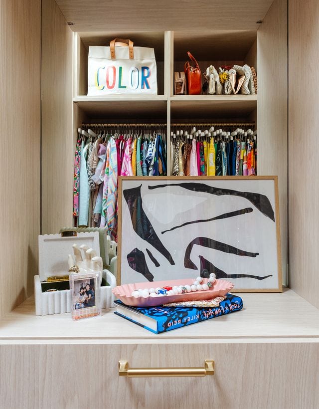 Joy Cho's walk in closet with vanity mirror and built in dresser drawers by California Closets
