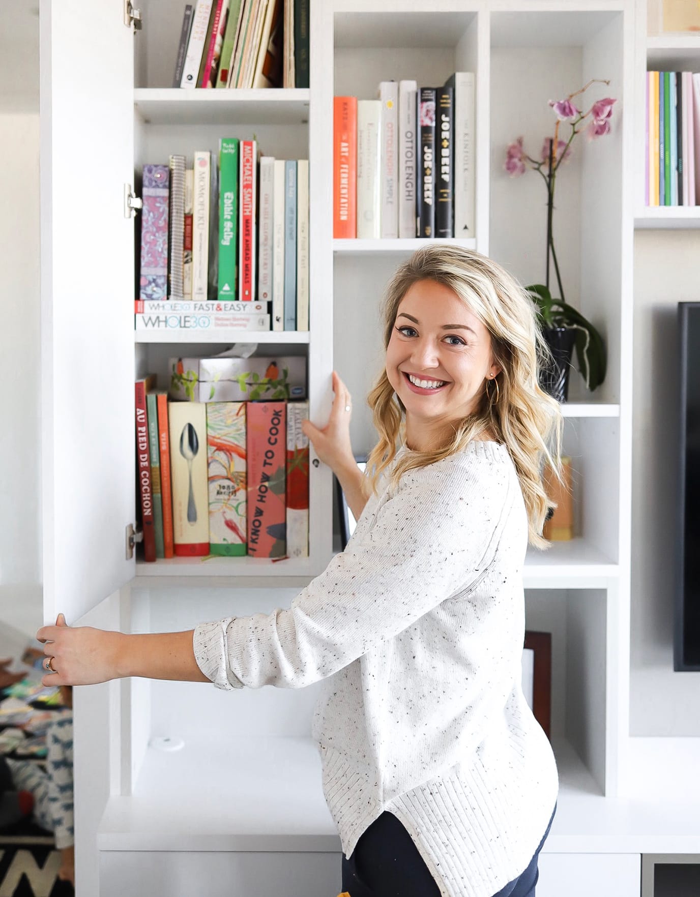 Emma Betty's custom media wall entertainment center shelving in her living room by California Closets