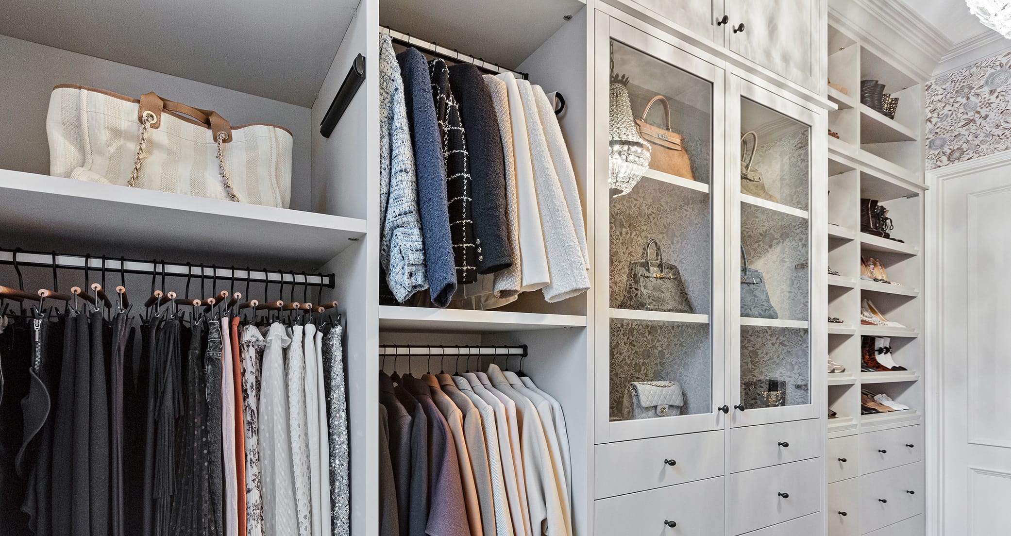 Walk in closet design with open shelves and glass doors with custom drawers by California Closets