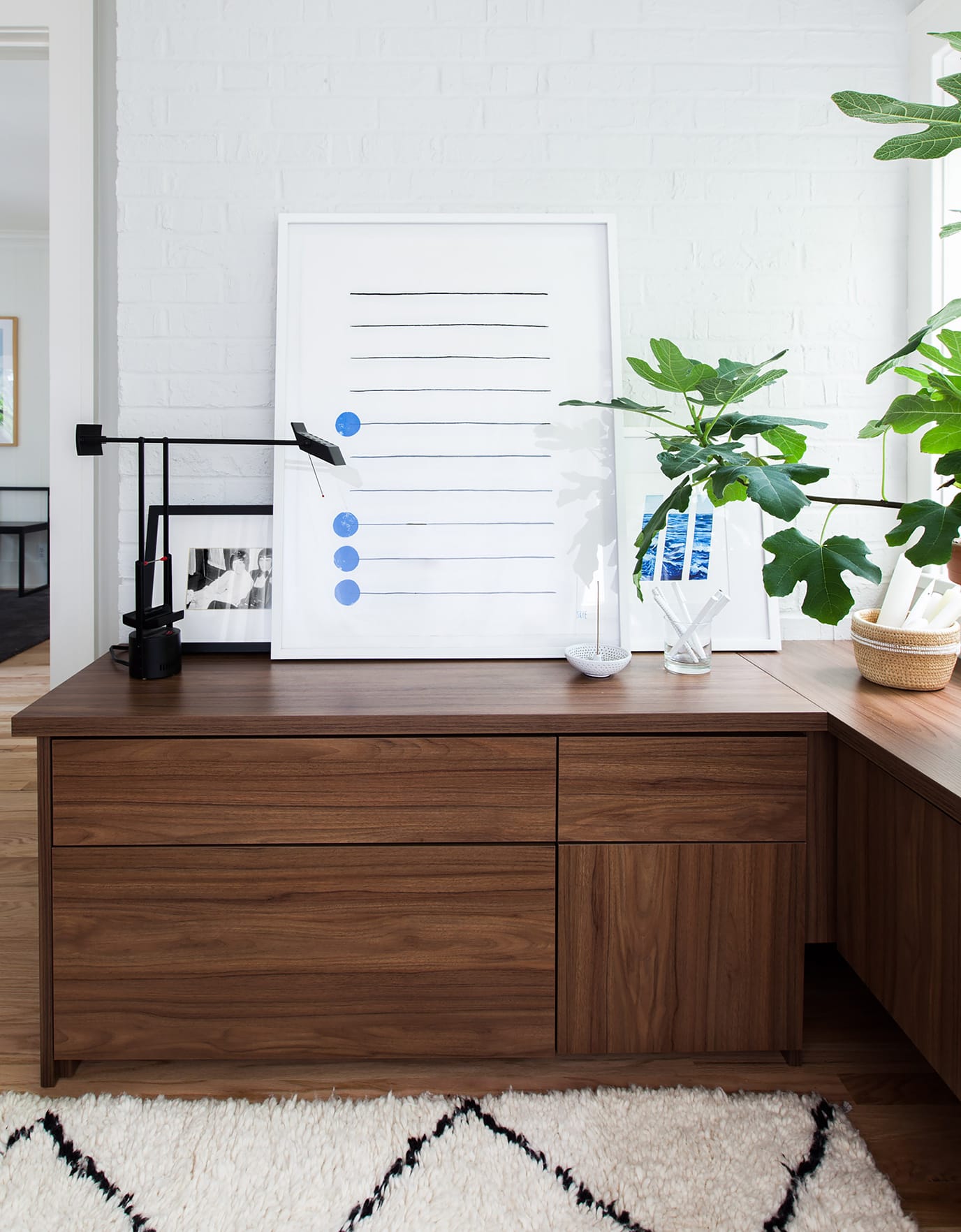 Work space designed with floating dark wood cabinets by California Closets