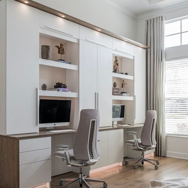 Dual workstations designed to maximize capacity with vertial shelving and custom cabinet drawers by California Closets