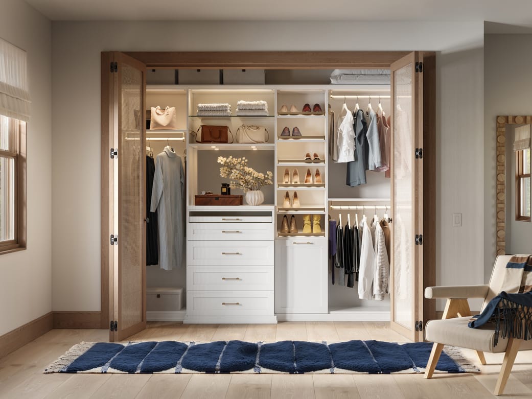 Closet with floating shelves and glass cabinetry in custom layout by California Closets