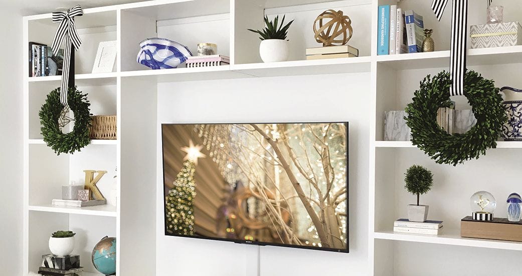 Custom built entertainment center with holiday decor and wreaths from California Closets