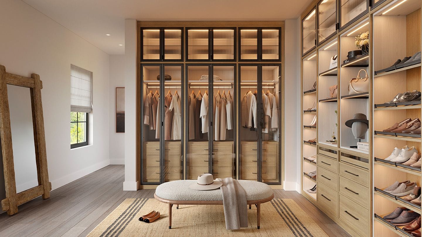 Elegant walk-in closet featuring dark wood finishes, integrated LED lighting, custom shelving, and shoe storage by California Closets