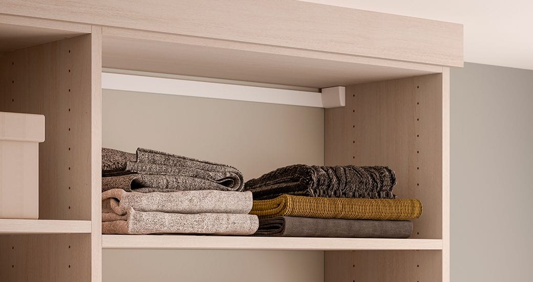 Folded sweaters in custom designed closet shelves design from California Closets