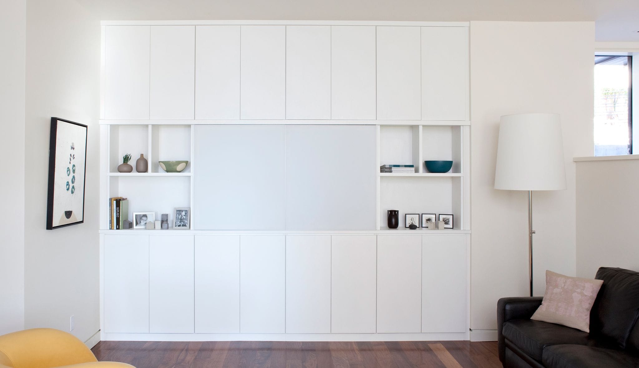 After a professional design and installation of an entertainment center with custom cabinets, shelves and television counter created by California Closets