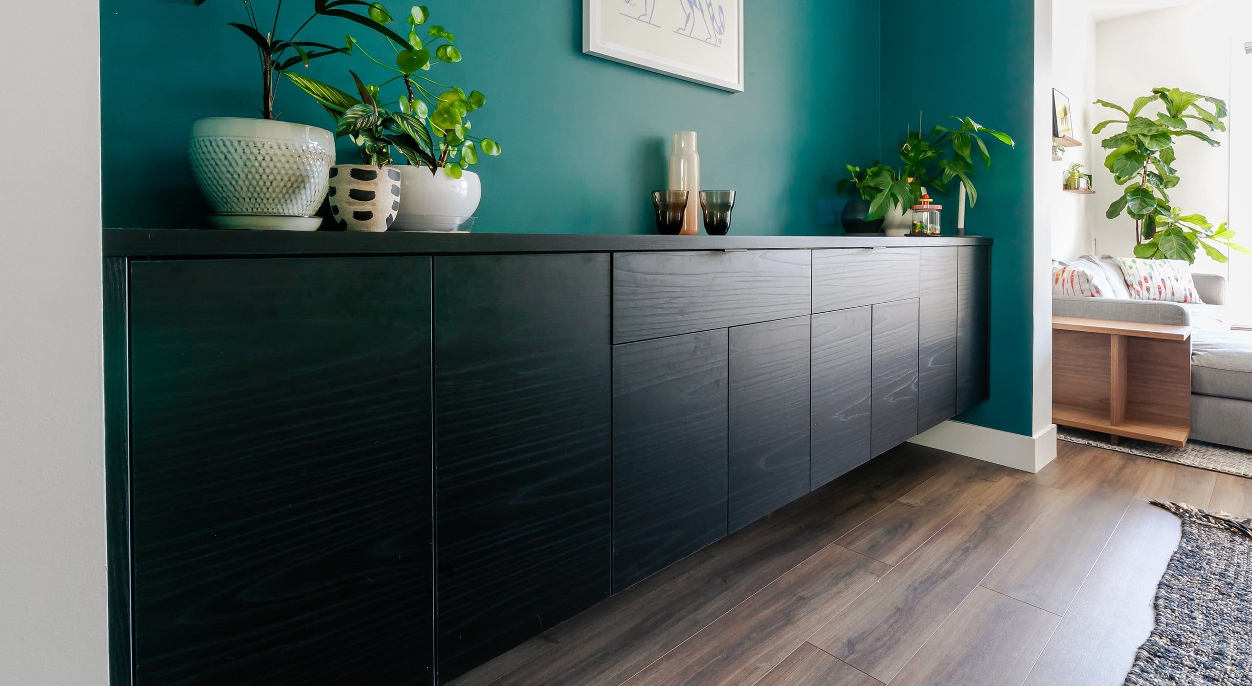 Floating media storage cabinets in dark wood finish by California Closets