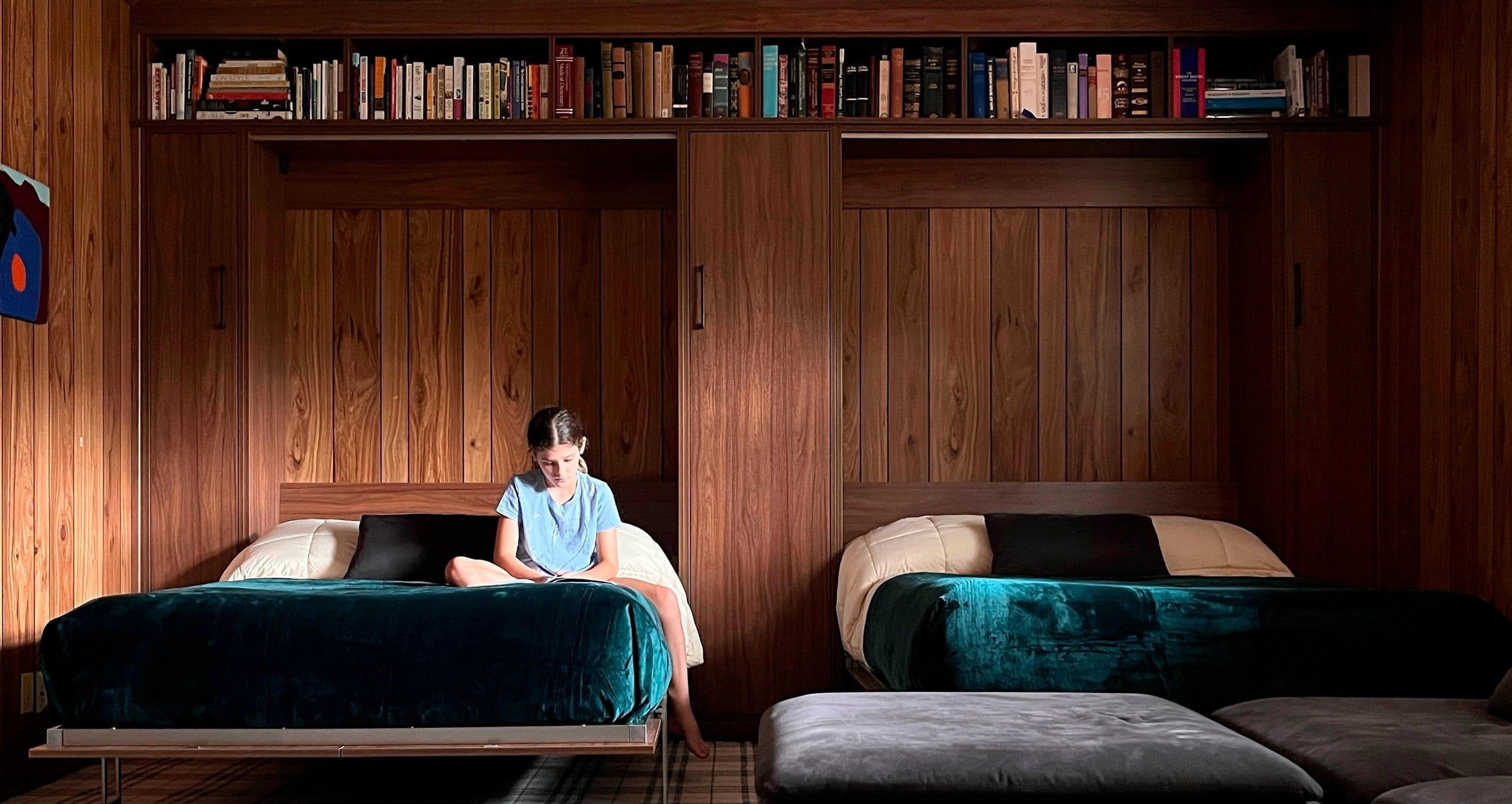 Opened double Murphy beds shown with book storage shelving in a dark wood finish from California Closets